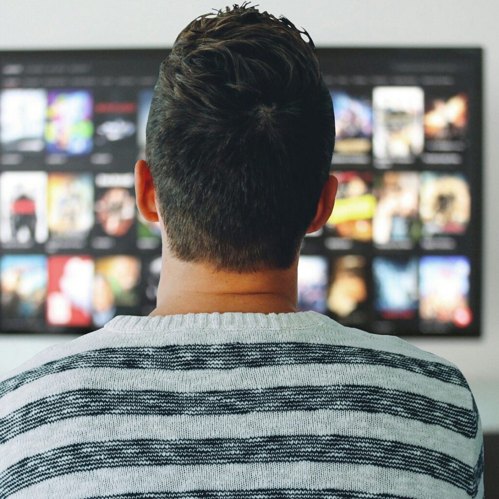 man watching television streaming platforms