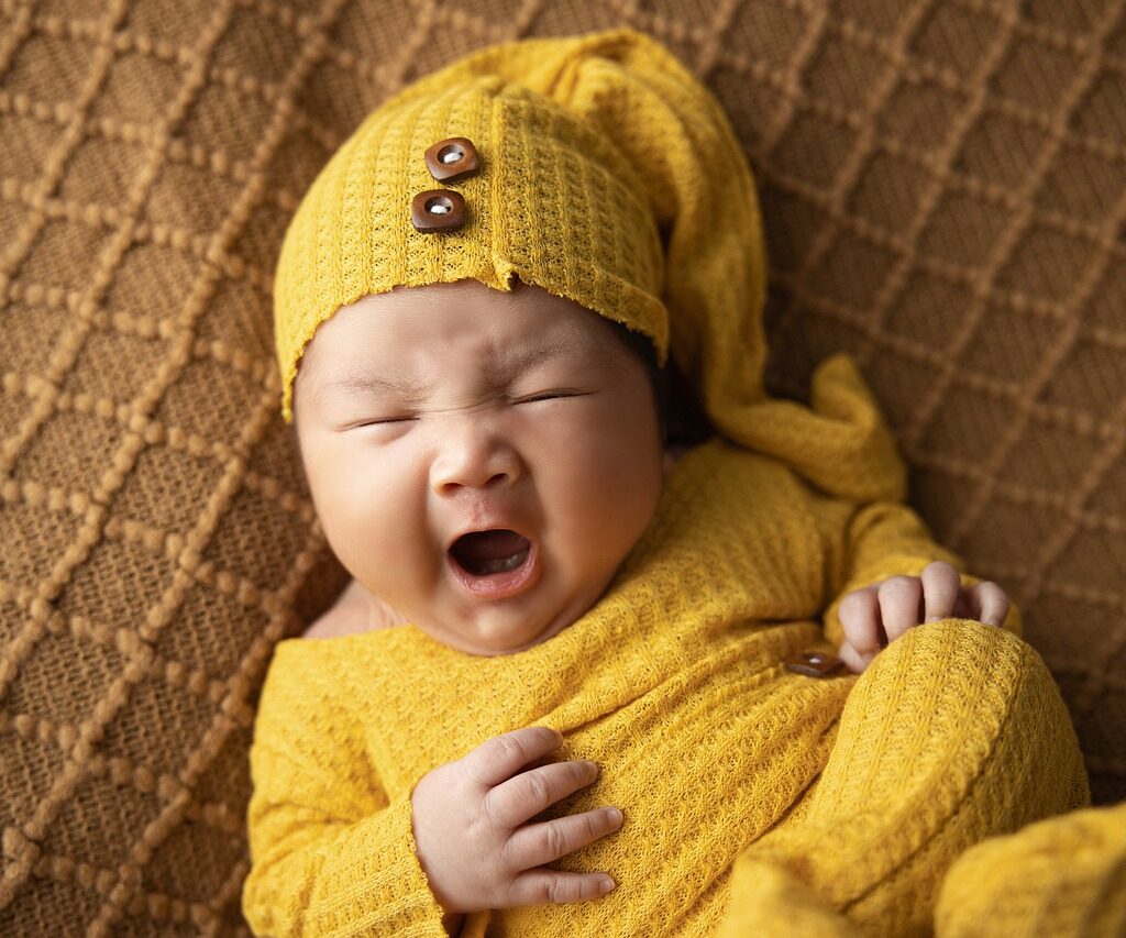 A woman dressed in yellow pajamas yawning