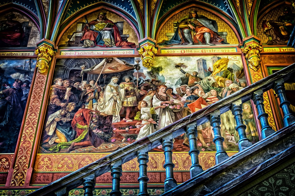 A wall of a religious mural depicting a medieval-like village.