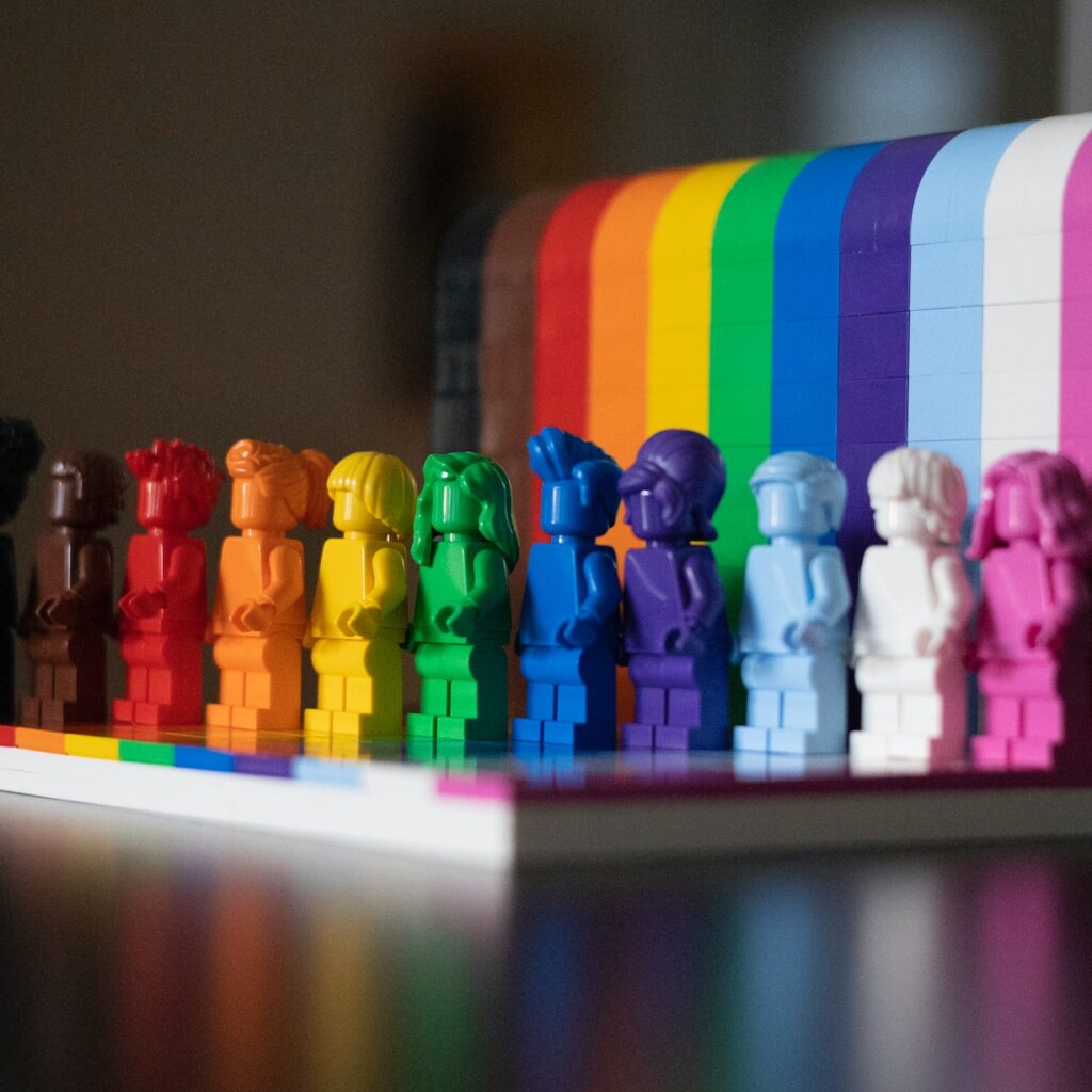 Legos of several painted mini-figures color coded to be a rainbow.