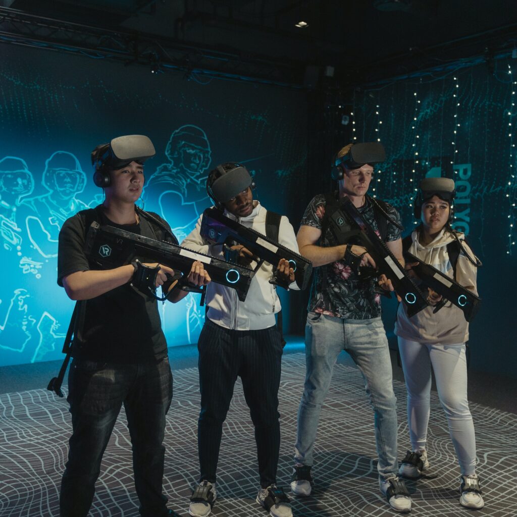 Four men standing with immersive touch weapons for a virtual reality game,