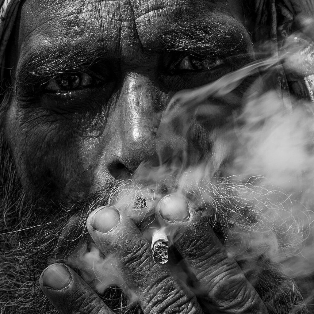 Black and white photo of man smoking representing portrait photography
