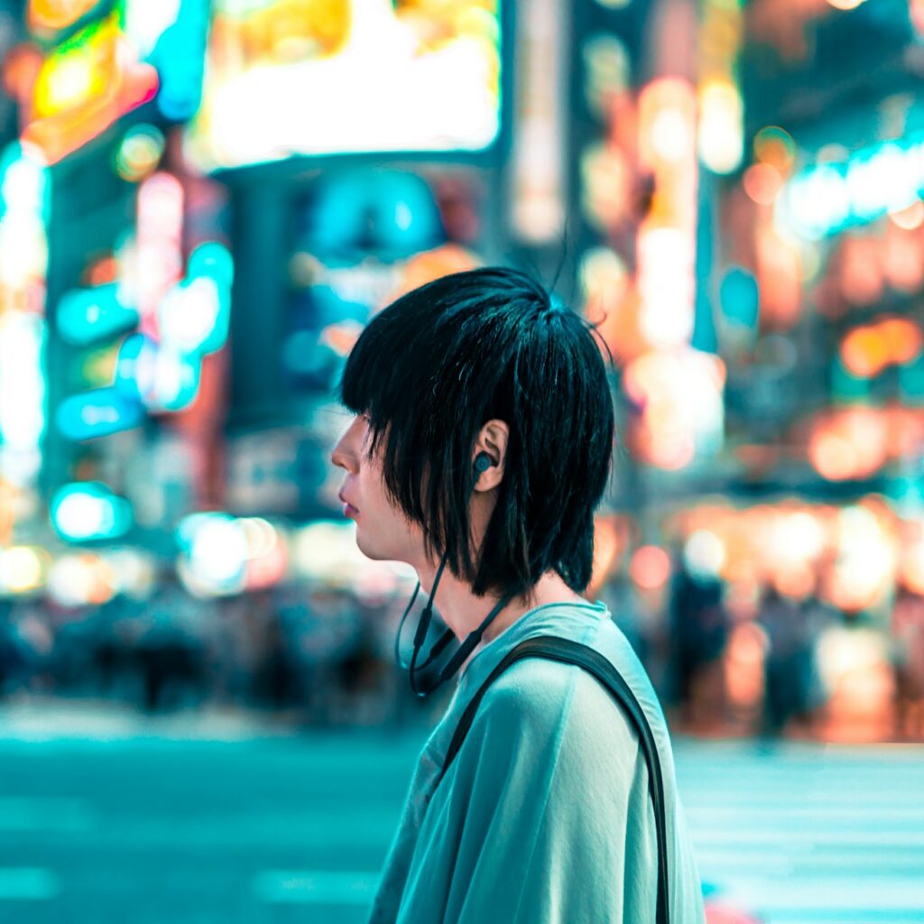 Man standing in Shibuya Crossing, Japan with earphones in ear.