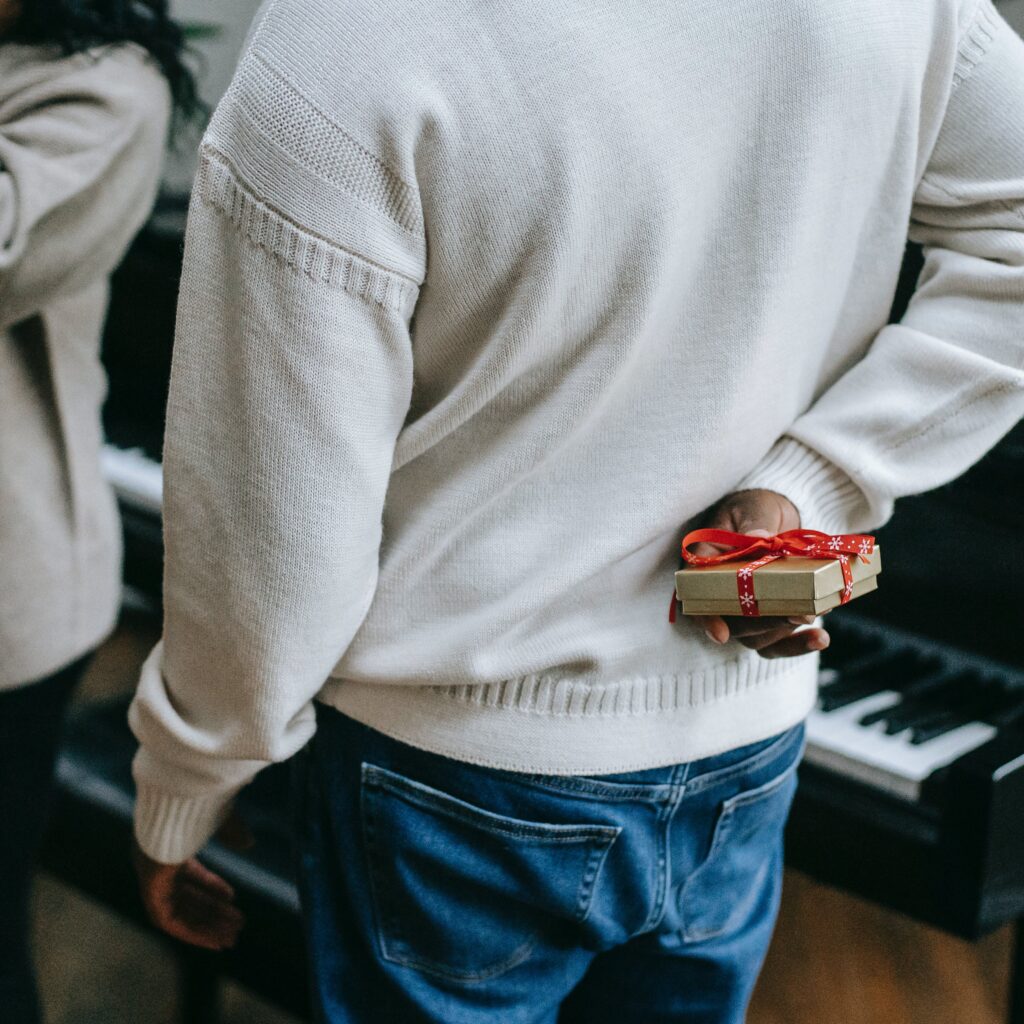 Man holding chocolates behind his back to give to woman for White Day.