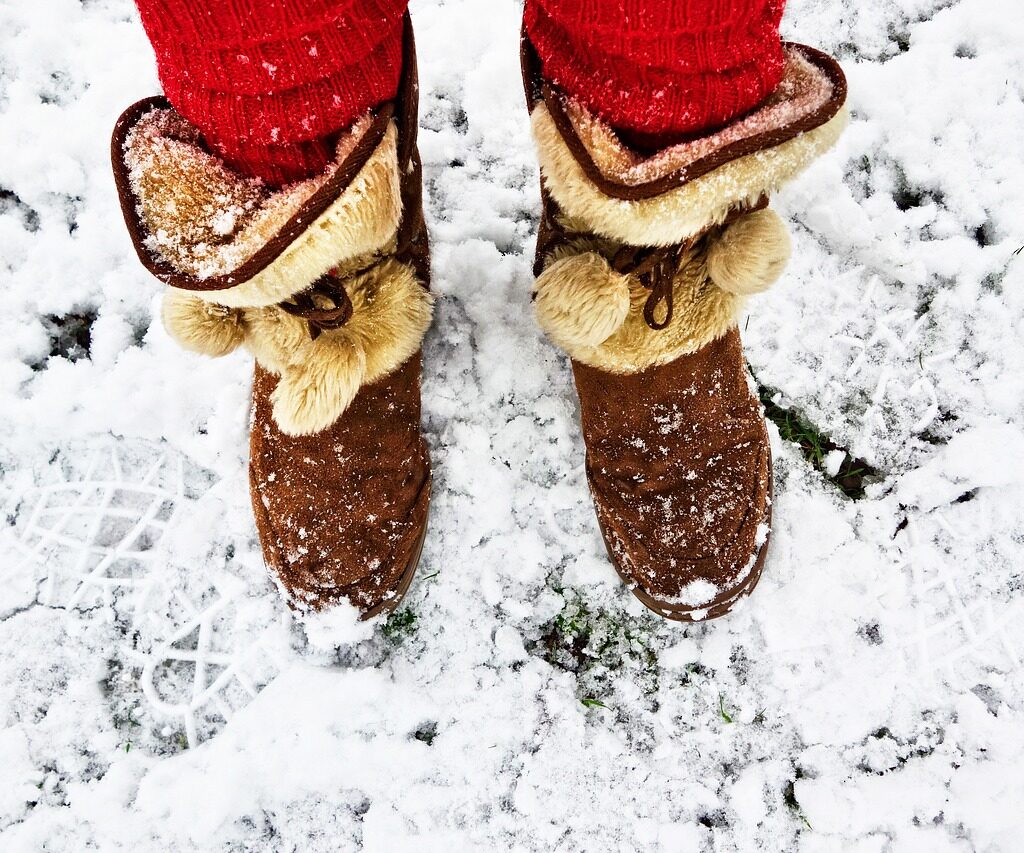 Image of person with warm winter boots and red leg warmers standing in show.