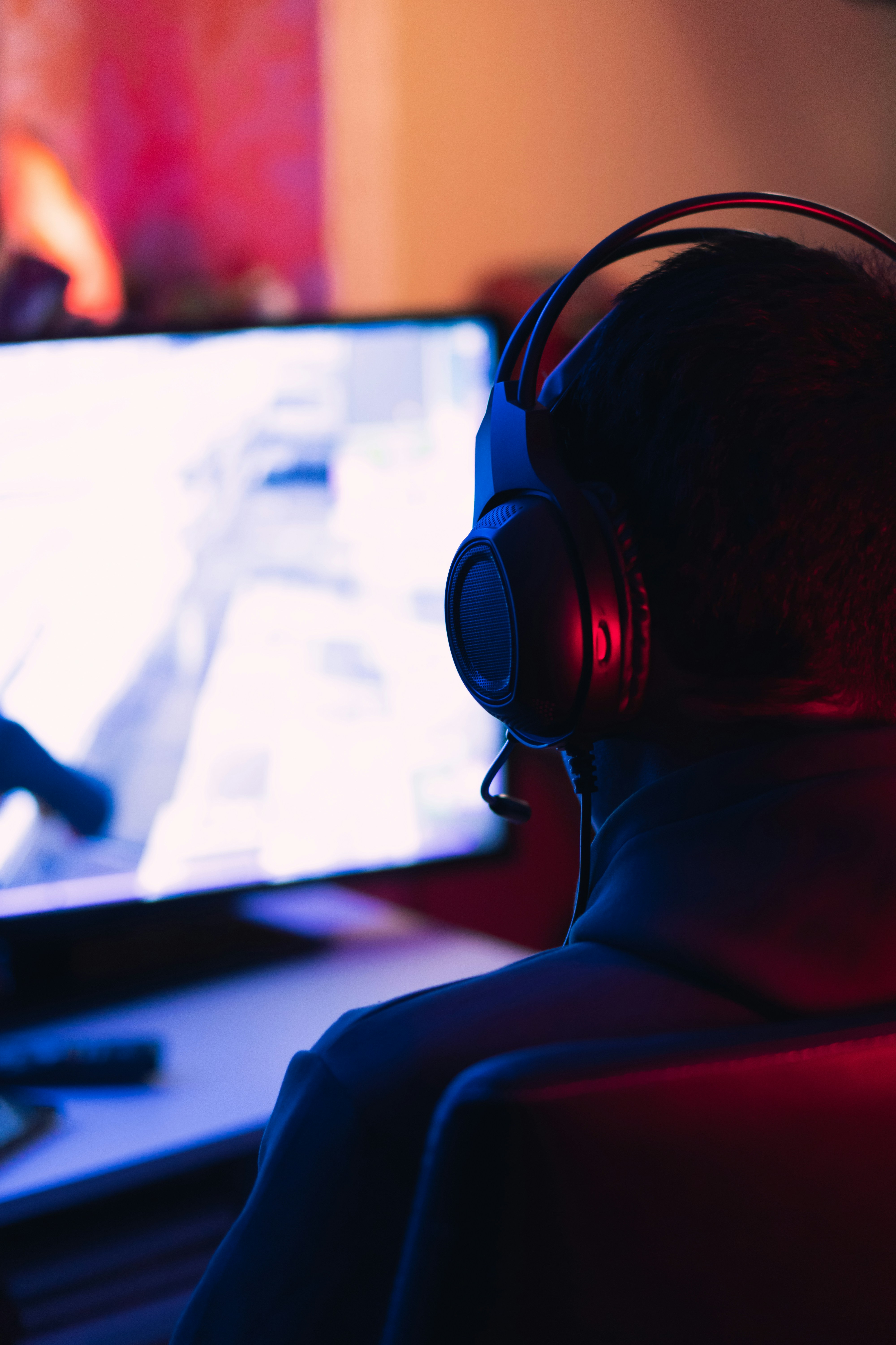 Man with headset and microphone streaming in front of computer