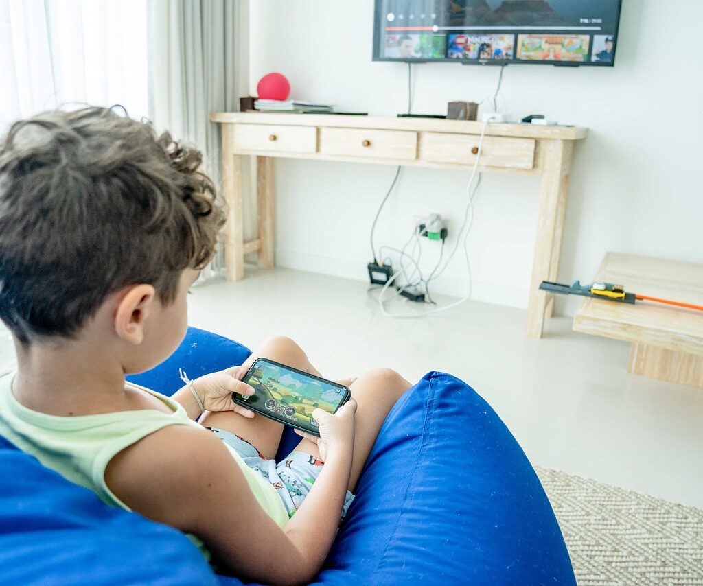 A boy playing a game on a phone. 