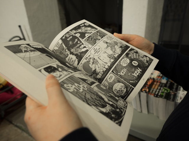 image of person in black shirt reading comics, or manga.