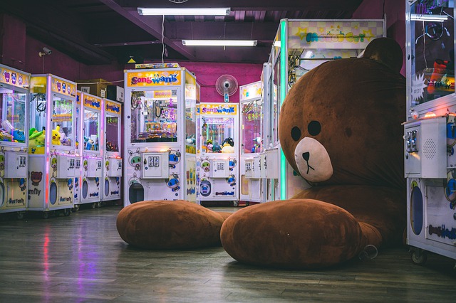 Teddy bear in arcade with games inside, including rhythm games.