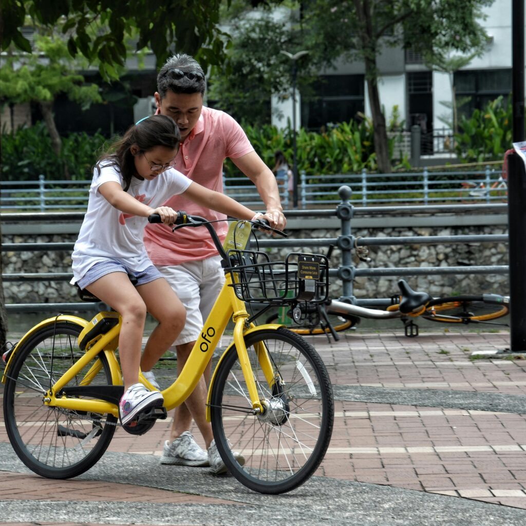 Father helping his daughter ride a bike