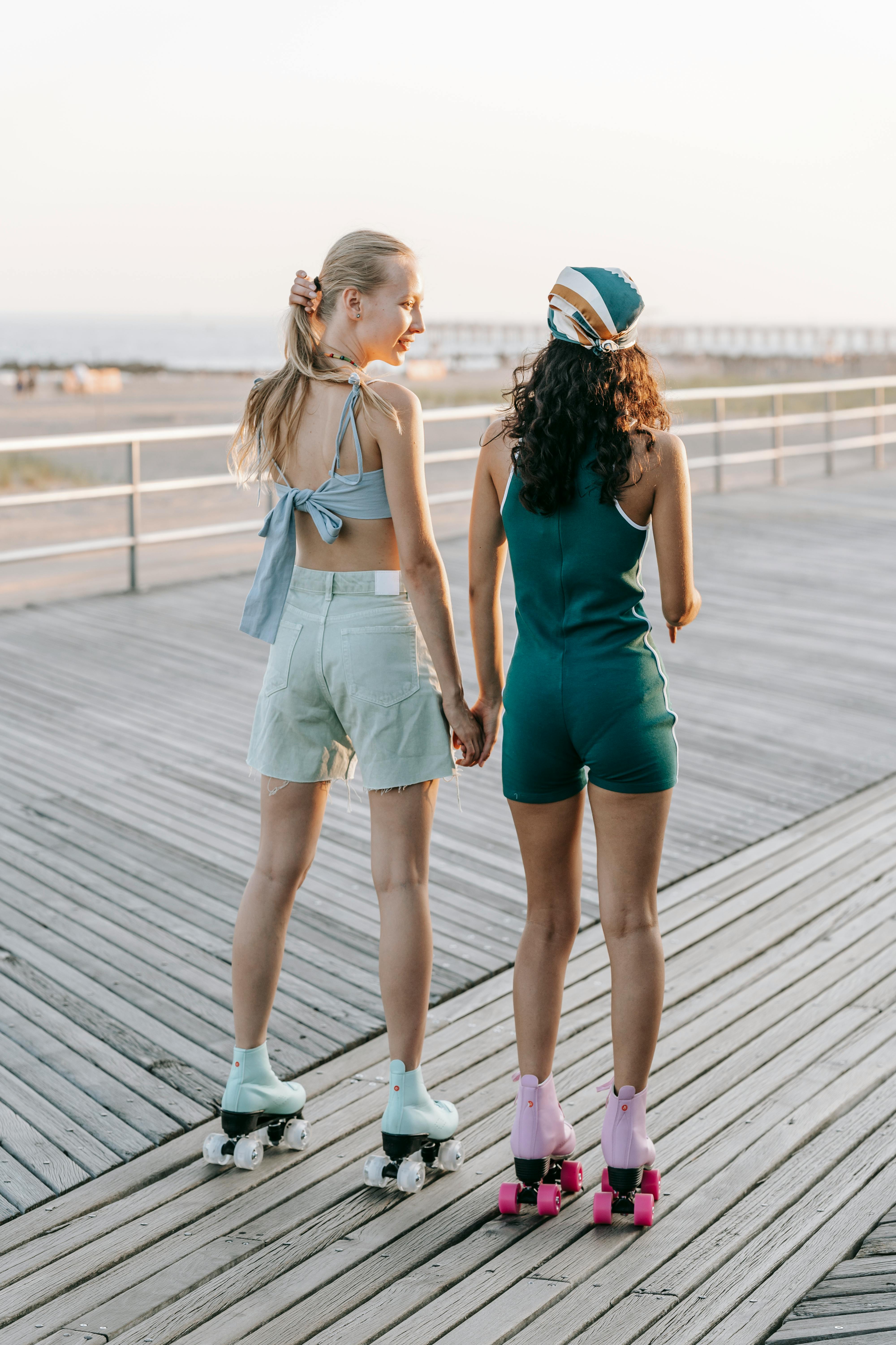 Two young women on roller skates skating next to each other