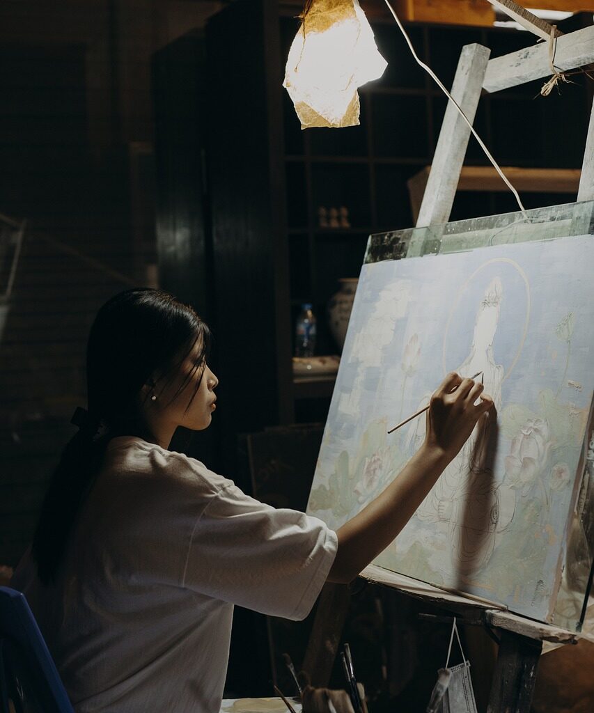 female artist painting on easel