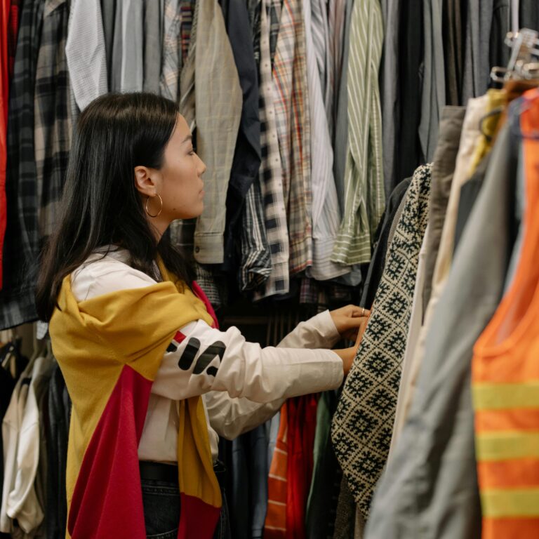 Young woman looking through racks of clothes.