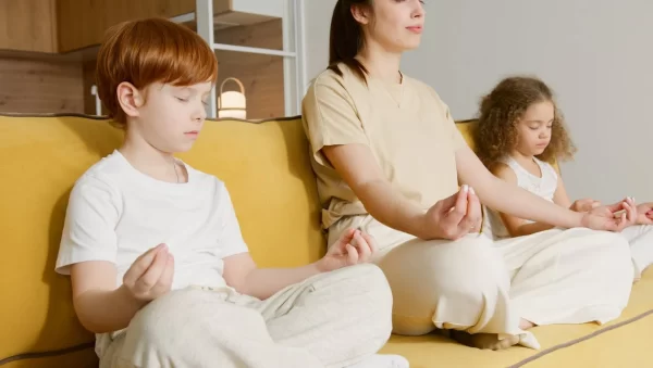 Family meditating on couch.