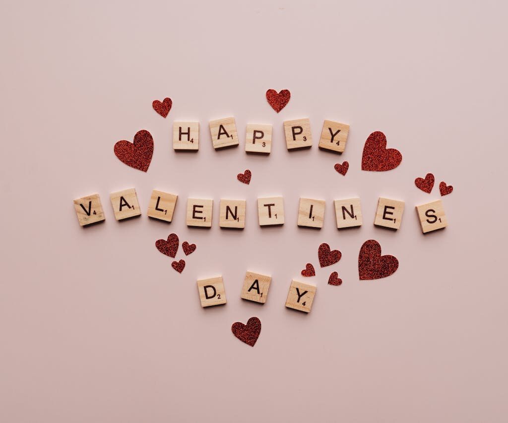 letters spelling valentine's day with hearts with a pink background