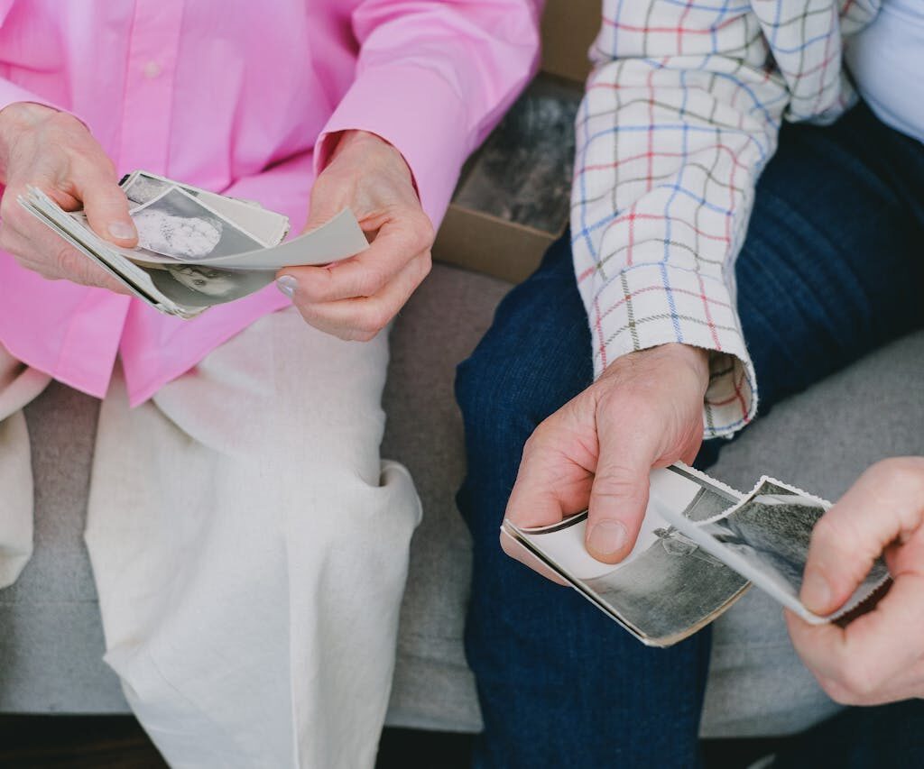 two people with photographs in hands