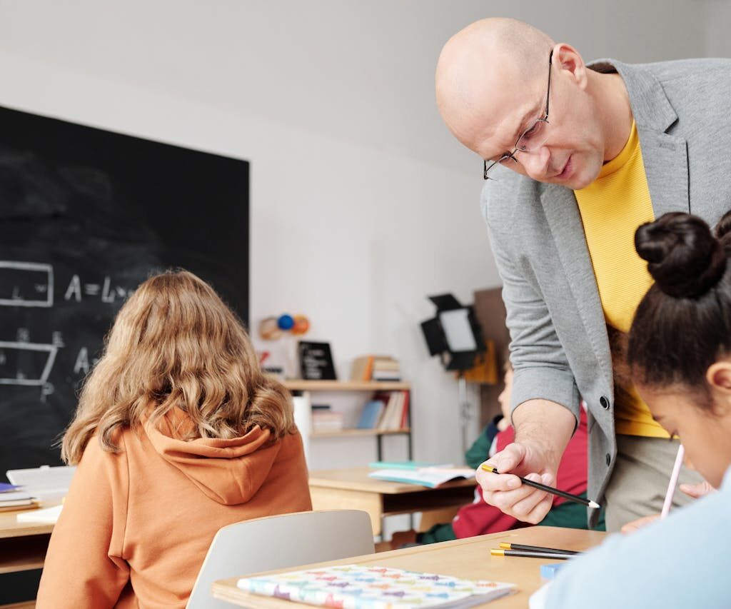 teacher helping student in classroom