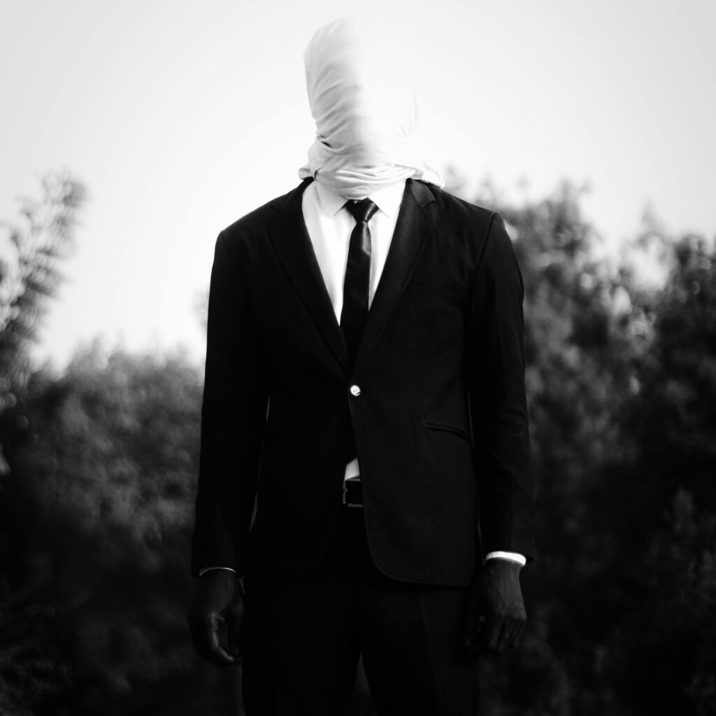 Man in suit face covered 
