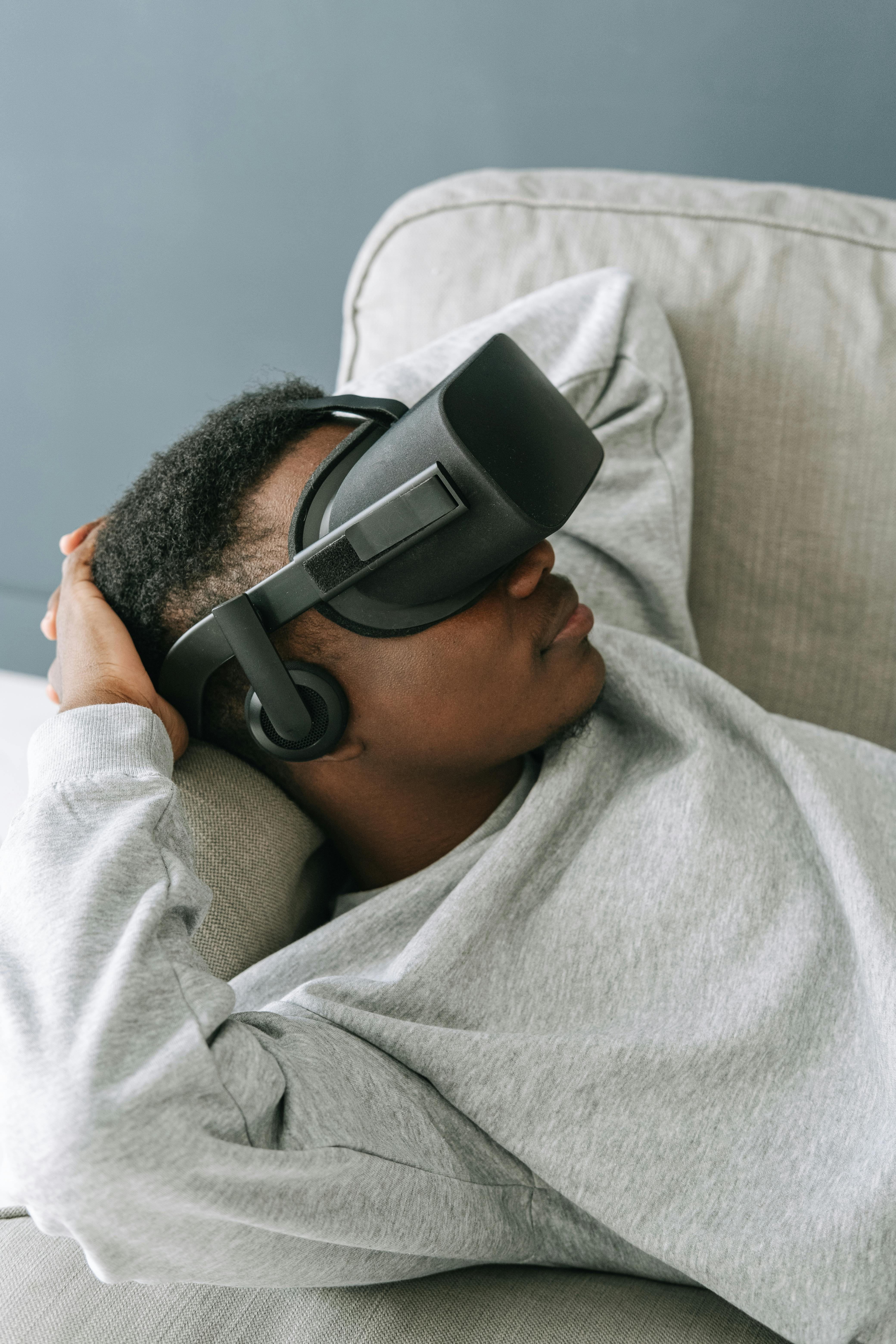 man laying on couch with VR headset