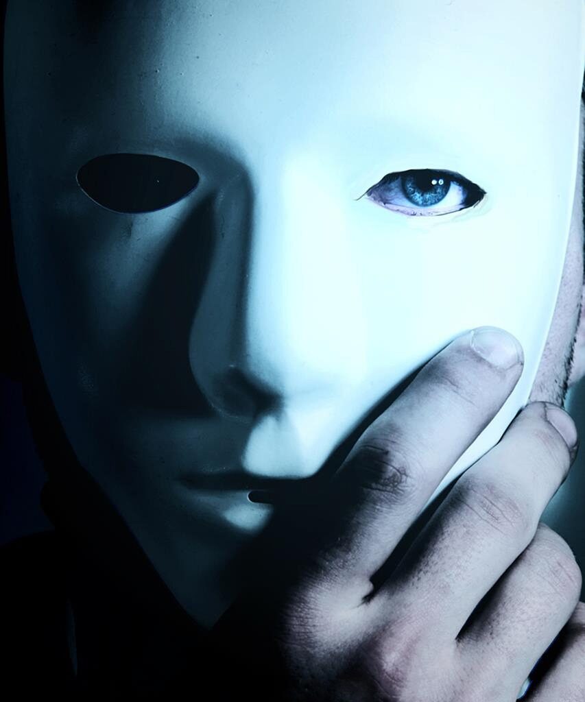 Person holding a white mask against their face, one eye visible through the mask's cutout